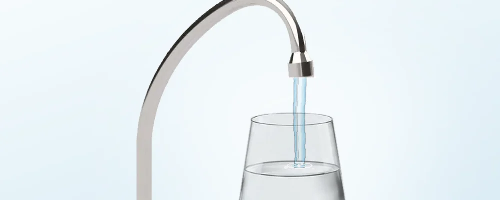 Rubinetto che versa acqua limpida in un bicchiere